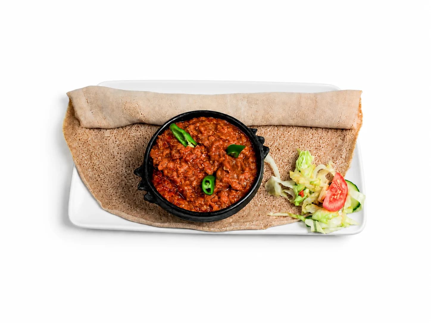 Rote Linsen in einer schwarzen Schale mit Salat und Injera