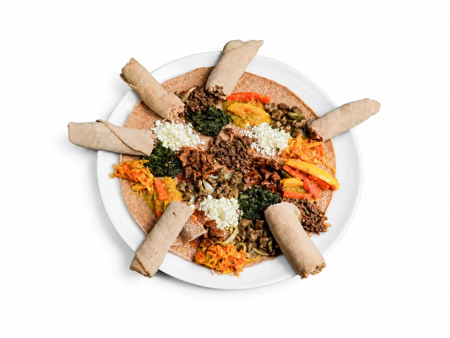 Runde gemischte Platte mit mehreren Gerichten und gerollter Injera